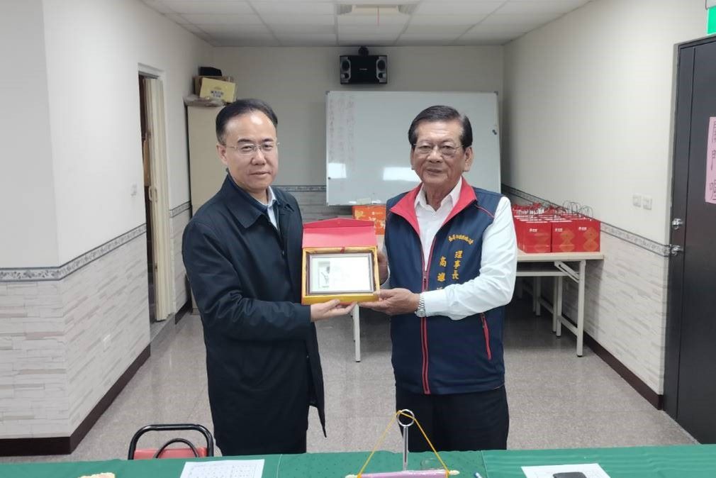 中國職工交流中心主任張廣回贈紀念品.jpg