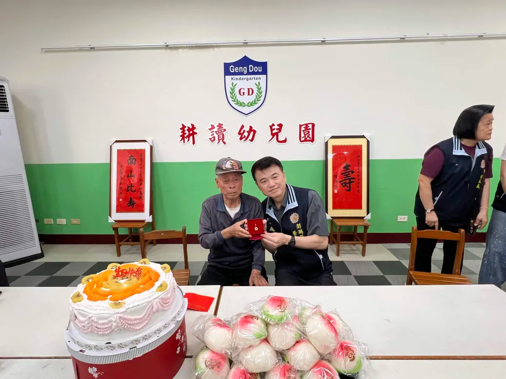 余處長代表輔導會主任委員致贈納福金鎖生日蛋糕壽桃等壽禮.jpg