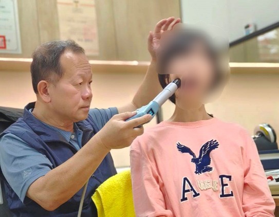 圖二中山附醫智慧賦能中心林志峰主任對病友曾小姐進行震波治療